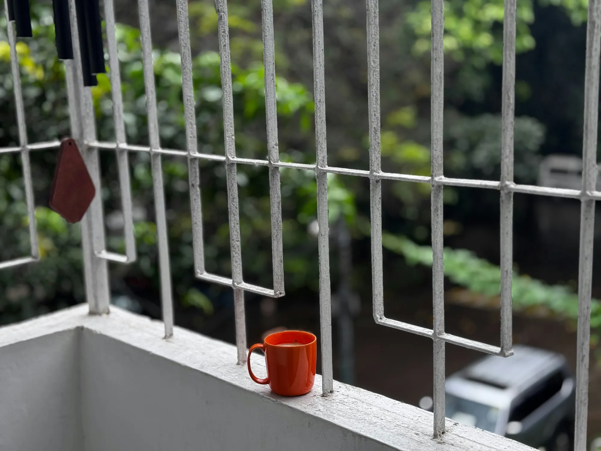 Kubek na balustradzie balkonu wśród zieleni